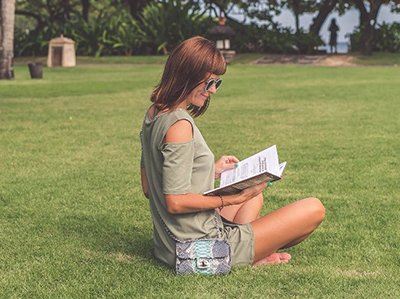 Image of a woman sitting on grass and reading