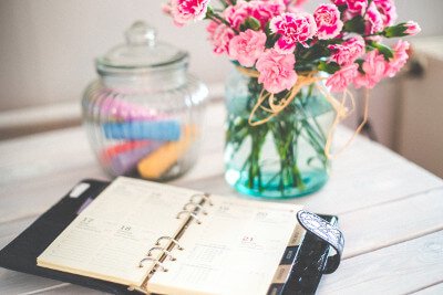 a scheduler and flowers on a desk