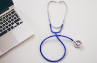 Stethoscope and laptop on desk