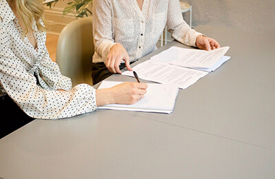 Two women signing documents