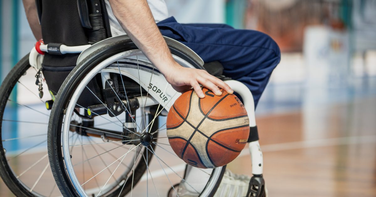 man in a wheelchair palming a basketball