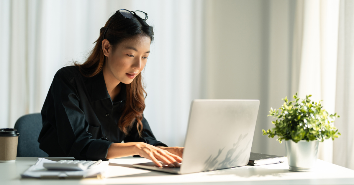 Woman working at her desk on a laptop.