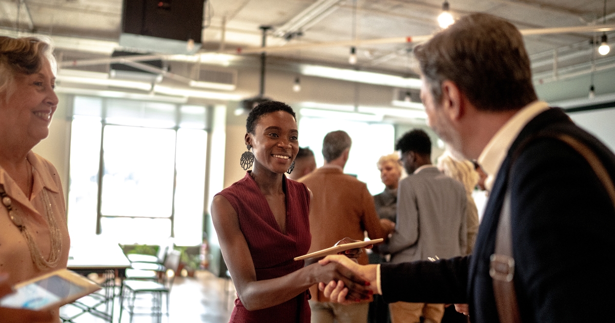 Two people shaking hands at an event.