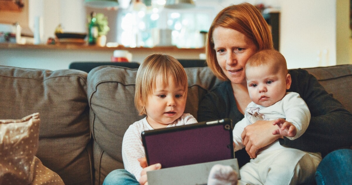 mother and two children looking at a tablet