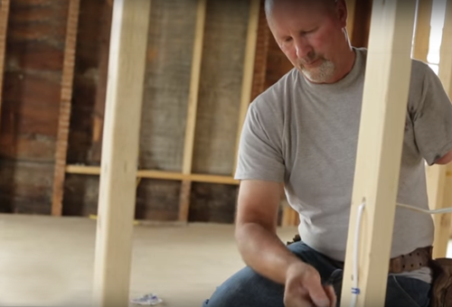 man working on house interior framing