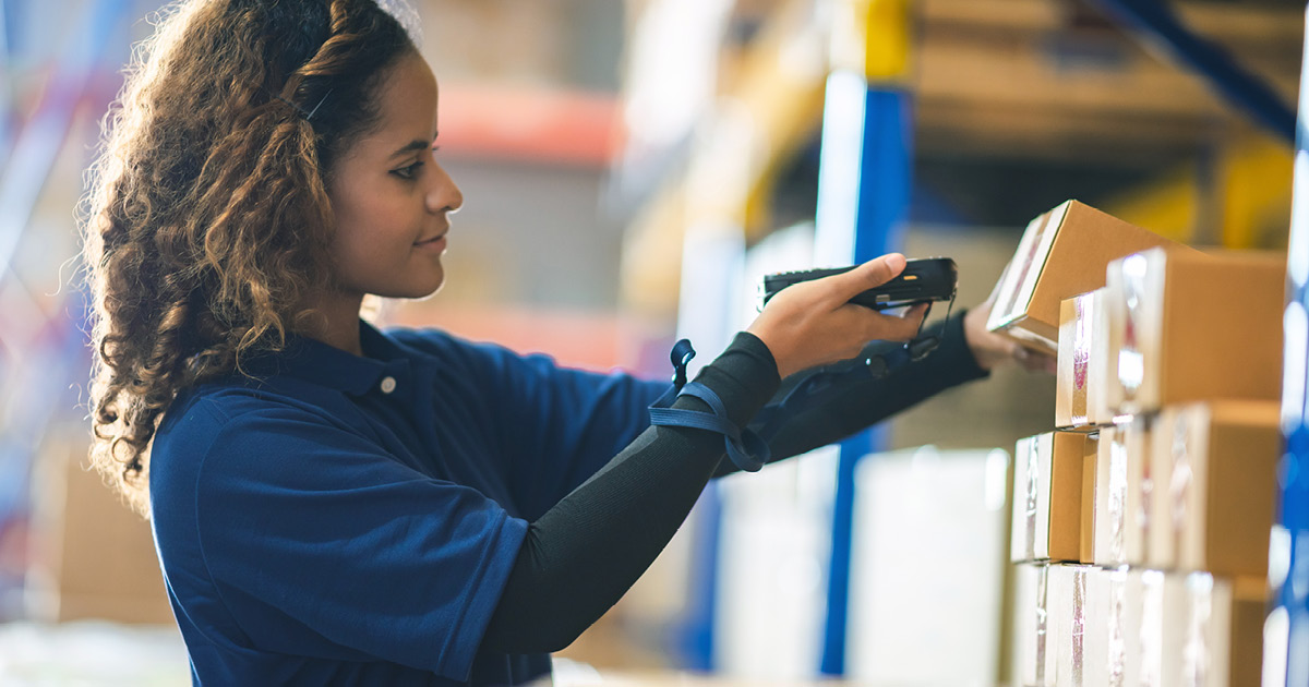 A person scanning boxes in a warehouse. 